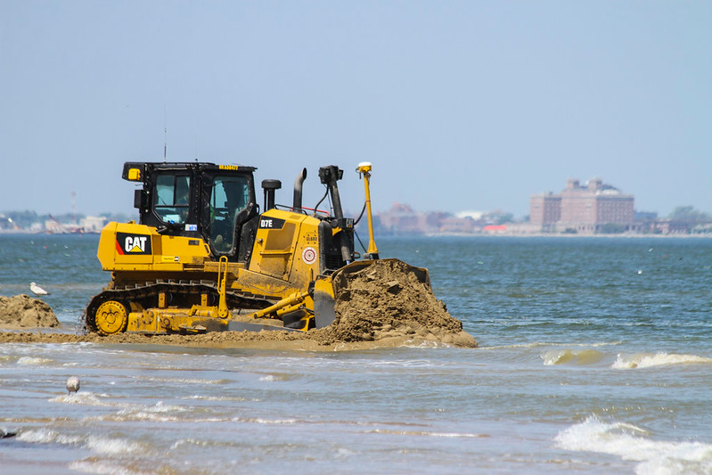 after sand was pumped onshore, bulldozers spread it to create a wider beach at Ocean View