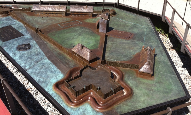 model of 1607 James Fort, a triangular wooden structure with half-moon bastions at each corner where cannon were placed on raised platforms