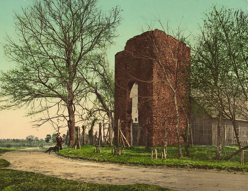 the tower in 1902, before the Colonial Dames of America built a brick reconstruction of the associated church (the temporary wooden frame building protected the foundations of the 1617 church)