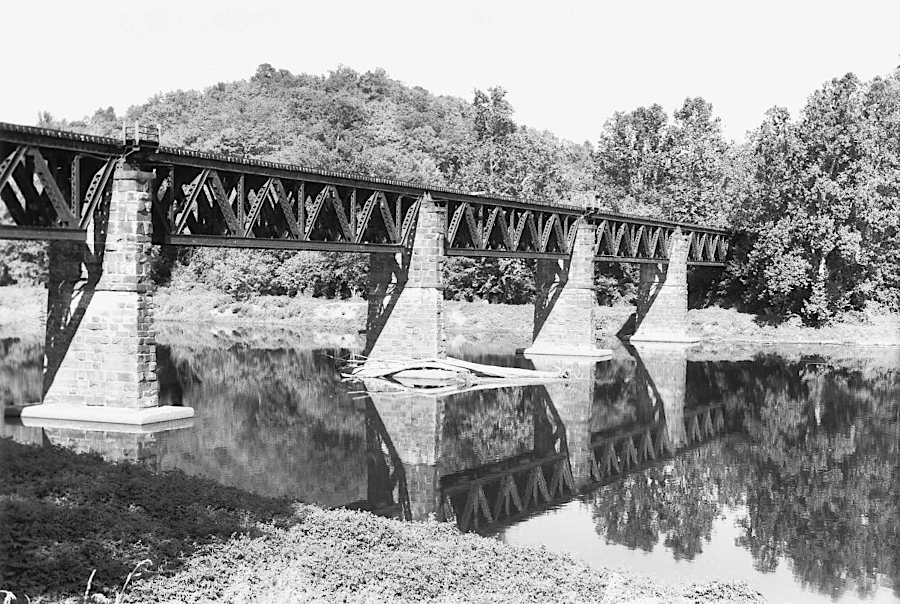 the First Crossing of the James built by the South Side Railroad in 1855 was a wooden bridge burned in 1865, then rebuilt in 1870 as an iron structure that became known as Six Mile Bridge