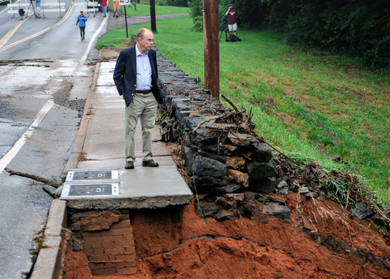 the president of the University of Lynchburg, viewing damage to the embankment after College Lake overflowed
